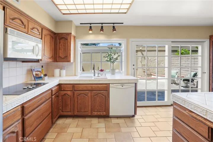 Kitchen facing patio area with bay window and double pane sliding door