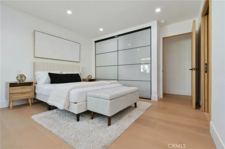 Convenient sliding-door closet system providing excellent organization in the secondary bedroom, featuring integrated LED-lit shelving with drawers