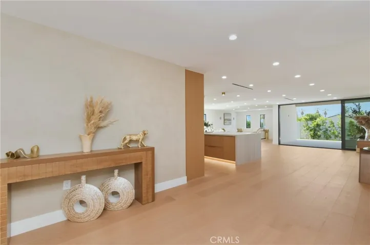 Bright, expansive main living hub highlighting a custom low-profile media console and seamless indoor-outdoor connectivity.