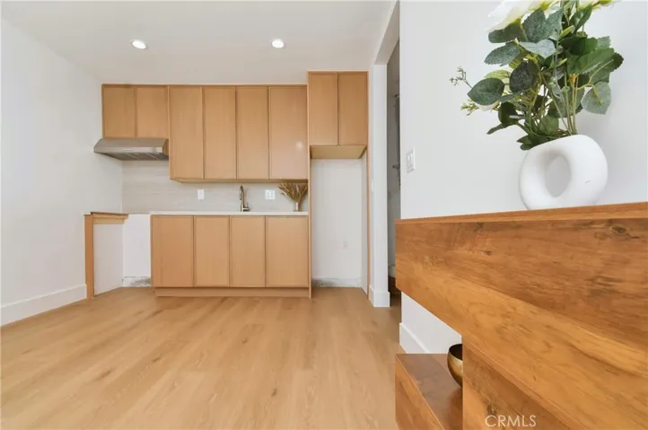 ADU kitchen featuring sleek, warm wood cabinetry, modern appliances, and a clean, minimalist design.