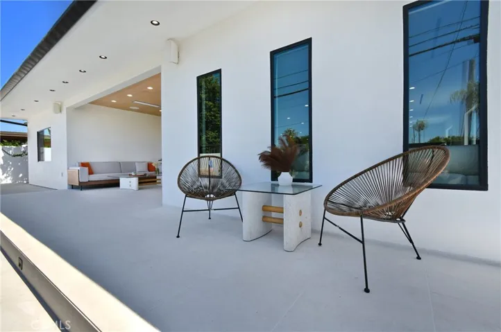Beautifully hardscaped side patio and walkway with clean lines and various minimalist seating areas