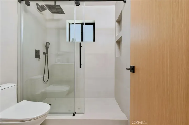 DU bathroom interior showcasing a pristine walk-in shower with contemporary tile work and a bright, functional layout.