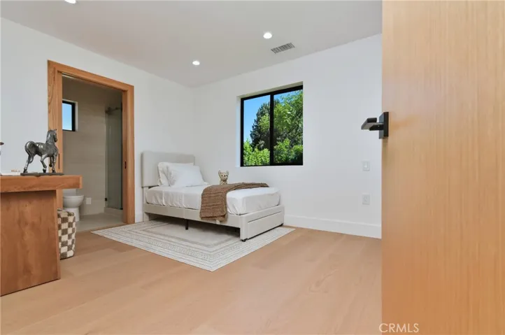 Generously sized bedroom retreat featuring a large window, plush flooring, and a tranquil atmosphere