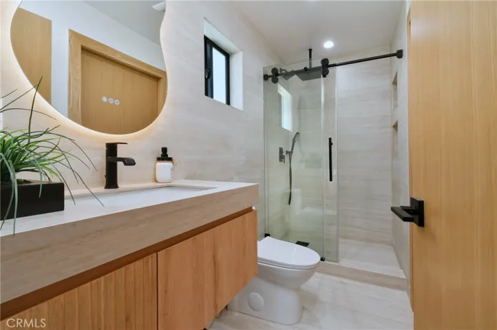 Spa-like bathroom boasting a modern floating vanity, contemporary fixtures, and a large glass-enclosed shower
