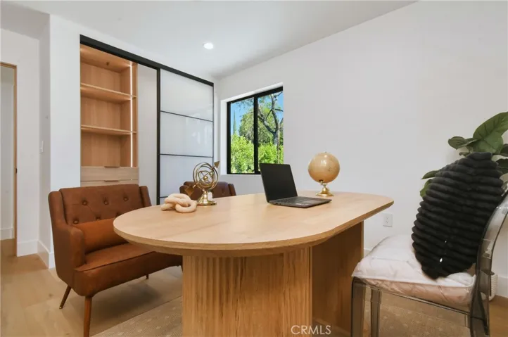 Flexible ADU space ideal for a home office or sitting area, featuring custom closets with LED-lit shelving, build-in drawers, and generous storage - ideal for a bedroom