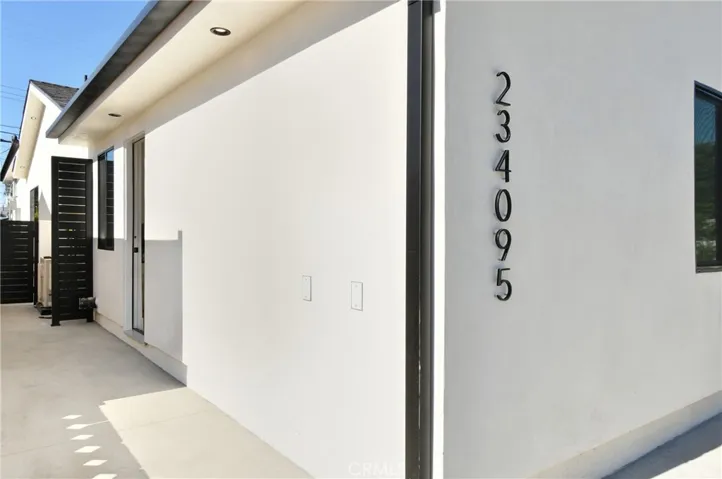 ADU exterior entry detail showing the sleek, modern address numbering on the crisp white stucco facadee
