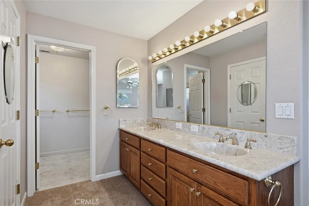 Stunning bathroom counters with double sinks, doorway to the bathroom and walk in shower, mirrored door to the spacious walk in closet