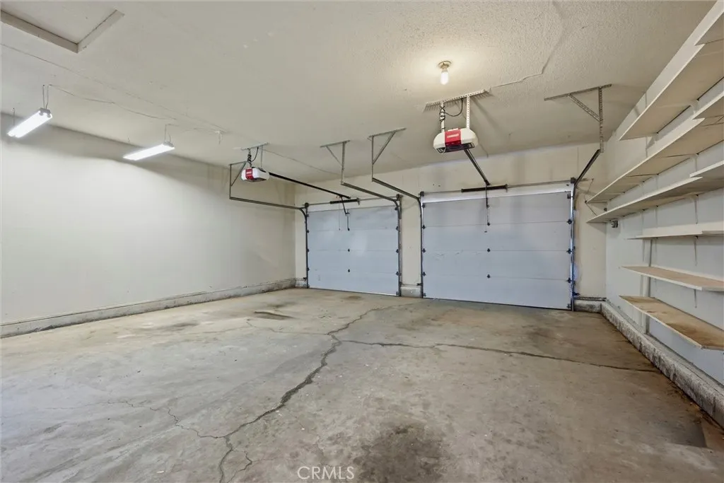 Spacious two door garage, with man door at the left to outside.  Plenty of shelves.  Two garage door openers