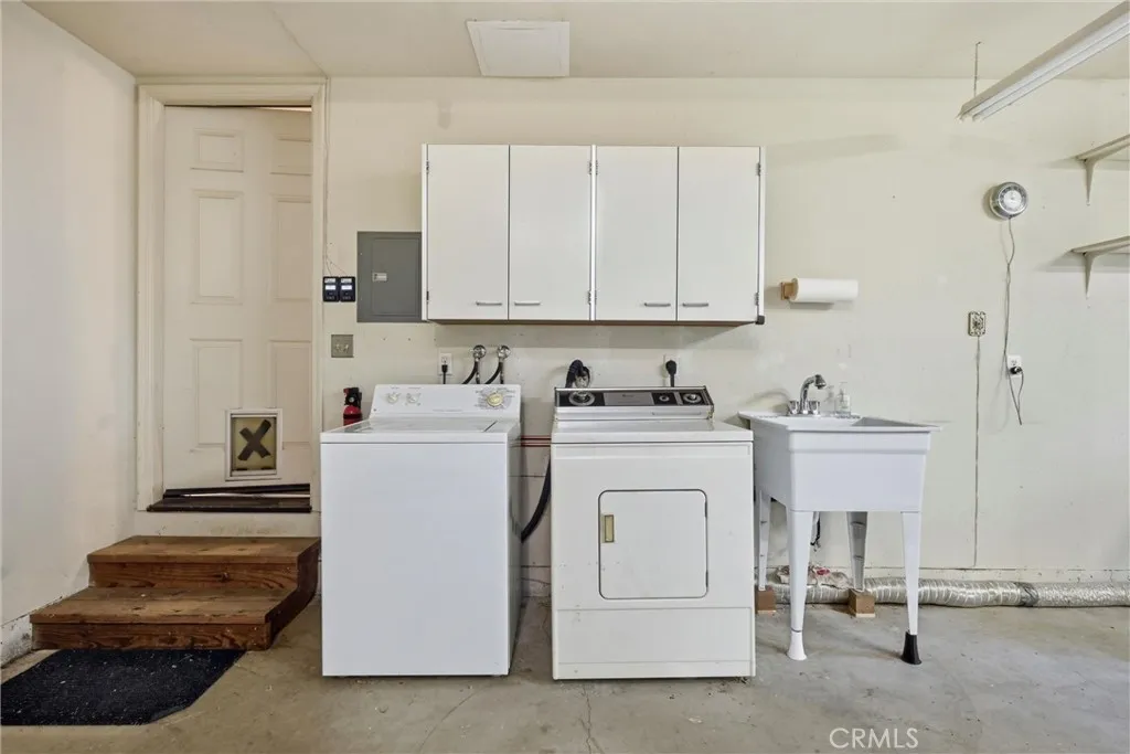 Just steps outside of the home is the washer, dryer, cabinets and laundry tub.........further to the right in the corner is the water heater