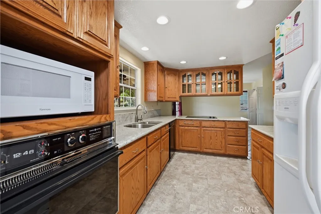 A very smart designed kitchen.  Built in oven, detached microwave, granite counters, stainless steel sink with disposal, stove top, refrigerator with icemaker and exterior water dispenser.  Opposite side of counter with cabinet above is a granite dining counter and a spacious room as a den or informal dining.  Room has a spacious closet, nearby is a 1/2 bath and  doorway to the garage Canned lighting is the perfect touch!