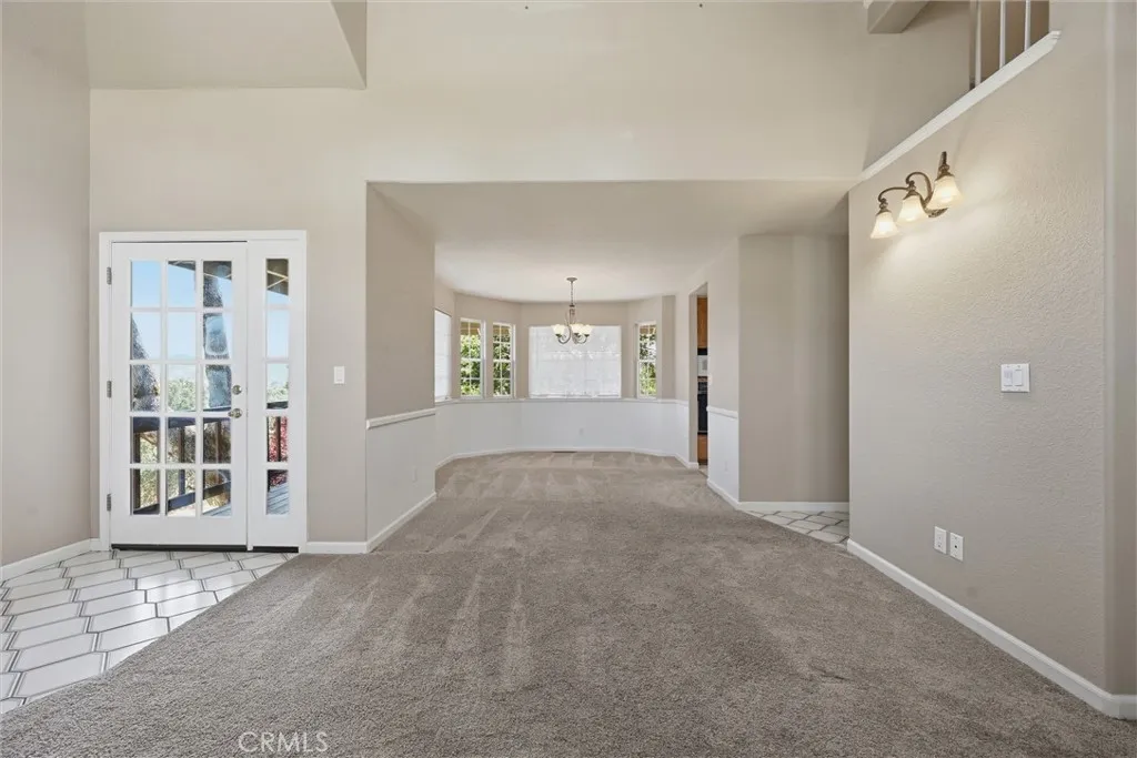 Dining room is very spacious; I believe it would easily accommodate a dining table with six chairs, possibly a sidebar.  Darker brown verticle line at right is the entrance to the kitchen, 2nd doorway to kitchen, family room, 1/2 bath and man door to garage