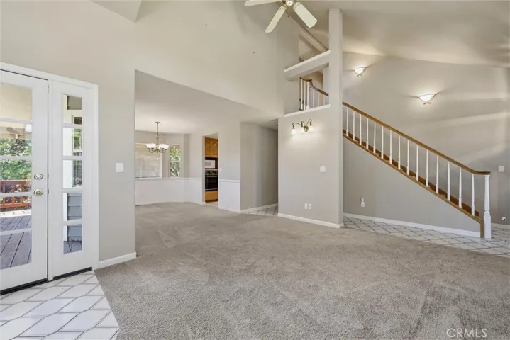 Peek a boo photo or electric oven and detached microwave in kitchen  Staircase is carpeted with wood at both edges of the carpet.  Tile floor in this area is the same in the family room.