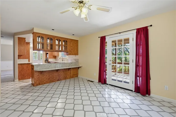 Looking back through the kitchen, notice the granite shelf available for dining. Around the edge of the kitchen is a hallway that leads to the staircase, living and dining rooms