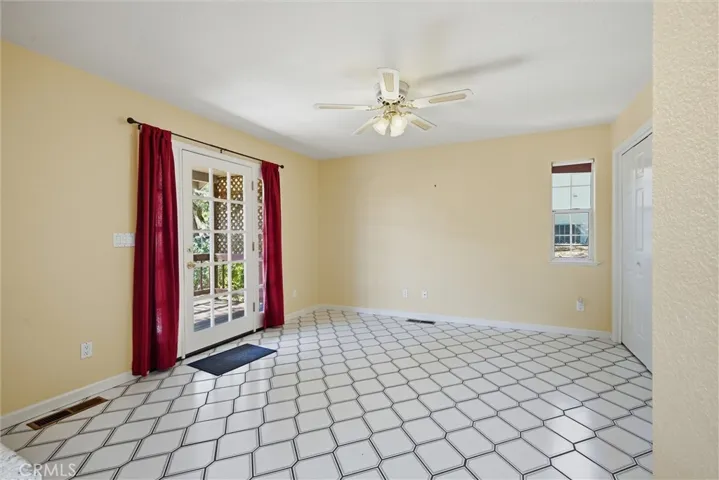 Room opposite kitchen.  Doors to the redwood deck and outside stairs to the back yard.  Tile floors, full closet
or office area on the right.  Ceiling fan keeps the temperature comfortable.