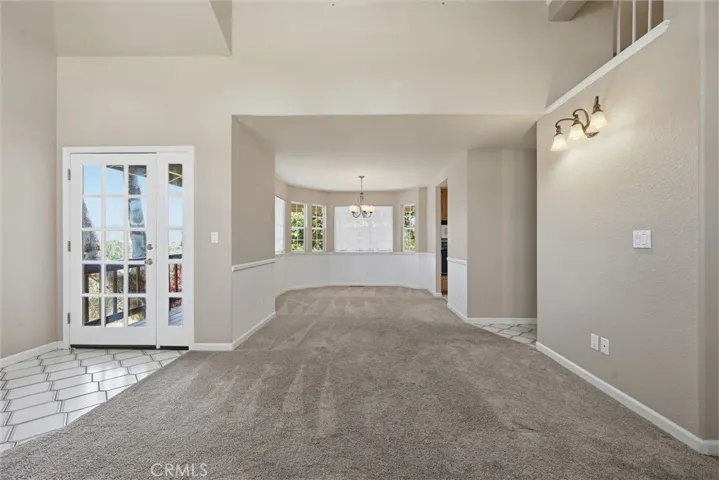 Dining room is very spacious; I believe it would easily accommodate a dining table with six chairs, possibly a sidebar.  Darker brown verticle line at right is the entrance to the kitchen, 2nd doorway to kitchen, family room, 1/2 bath and man door to garage