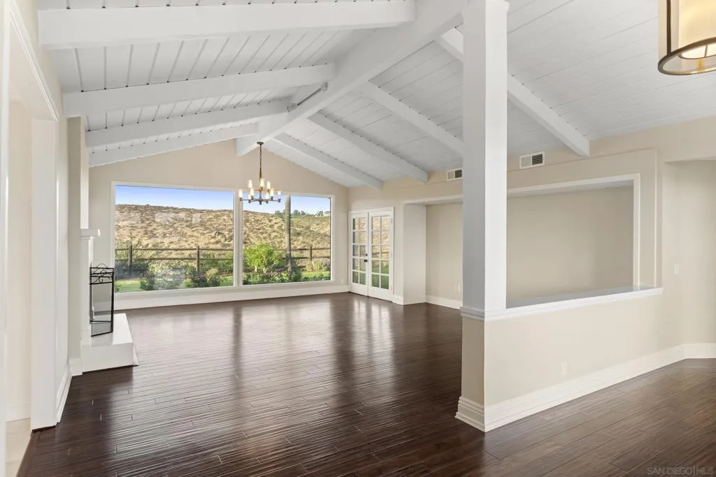 Formal entry into large living room with fireplace and french doors.  Picture windows with peaceful views.