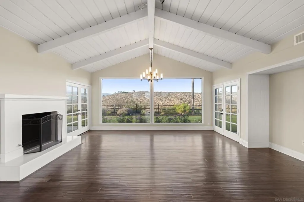 Large living room with fireplace and french doors.  Picture windows with peaceful views.