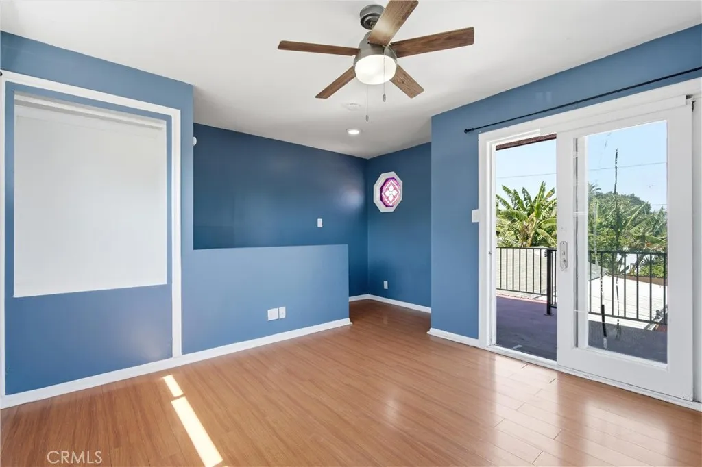 Third bedroom upstairs with laminated floors and balcony