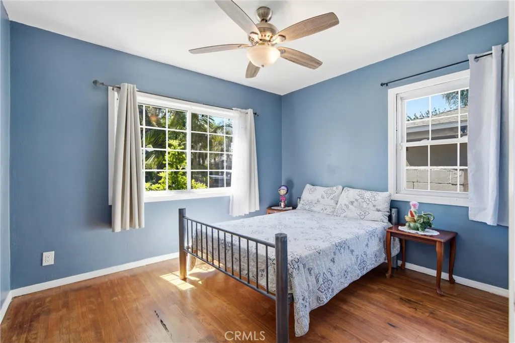 First bedrooom downstairs with lots of windows & hardwood floors