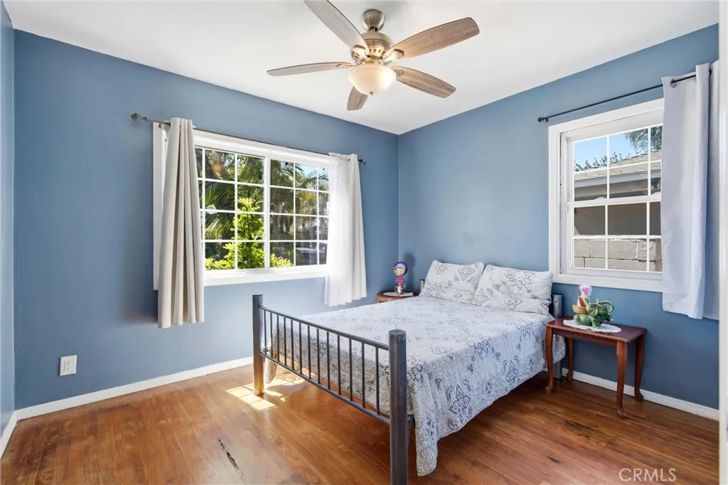 First bedrooom downstairs with lots of windows & hardwood floors