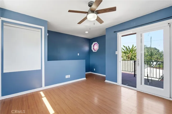 Third bedroom upstairs with laminated floors and balcony
