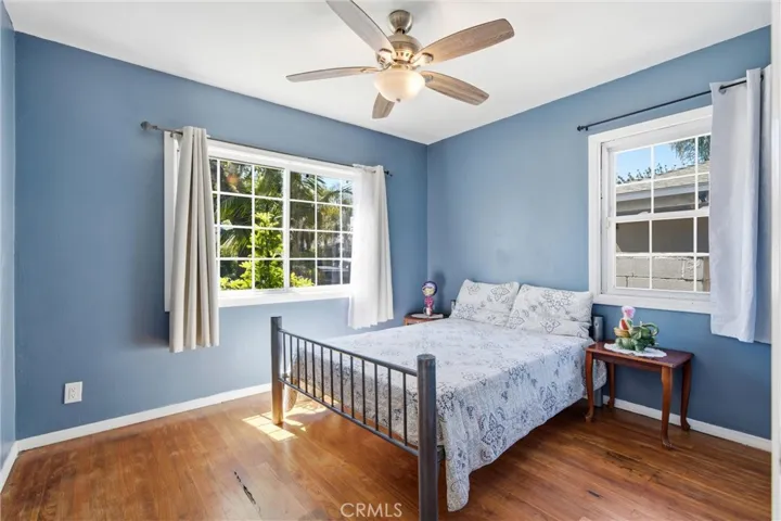 First bedrooom downstairs with lots of windows & hardwood floors