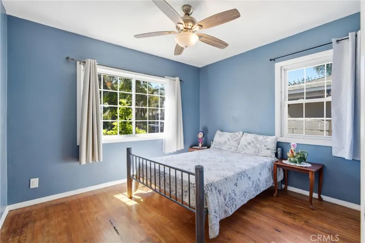 First bedrooom downstairs with lots of windows & hardwood floors