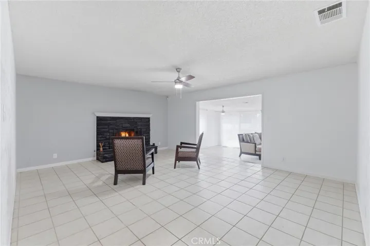 Living room with spacious family room in the background - flame digitally added
