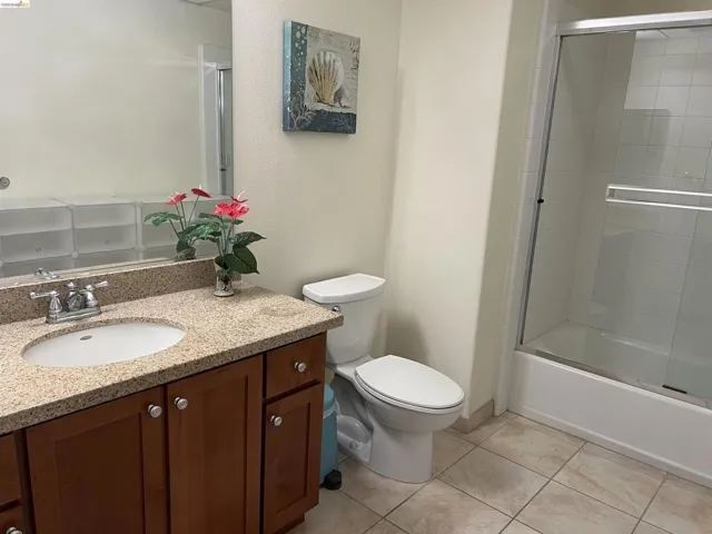 Bathroom featuring a single-sink vanity with a granite-style countertop and wood-finish cabinetry
