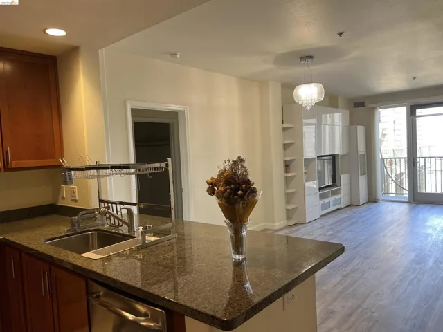 Kitchen island with stone-finish countertop, stainless steel sink, and dishwasher
