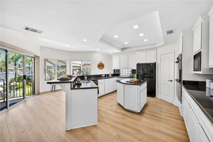 Freshly updated kitchen and filled with natural light, the kitchen offers panoramic lake views and opens to the spacious patio overlooking the water.