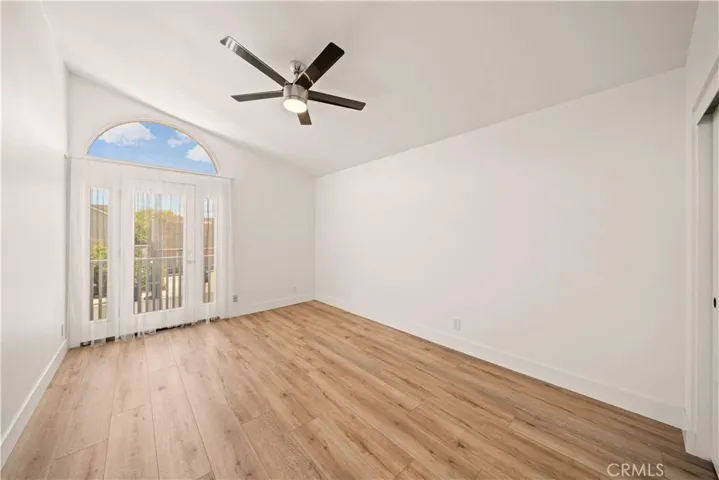 OVERSIZED GUEST BEDROOM WITH VAULTED CEILING & FRENCH DOOR opening to a Juliet balcony overlooking the front yard.