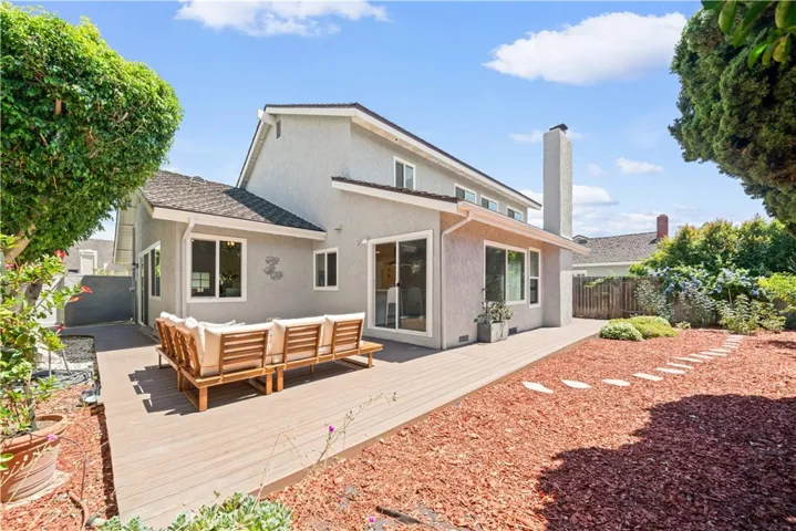 The backyard offers a serene, ZEN-INSPIRED garden retreat with a WRAPAROUND DECK, WINDING STEPPING STONES, MATURE TREES, BLOOMING ROSES, AND A VARIETY OF FRUIT TREES AND SEASONAL PLANTINGS — perfect for morning coffee, yoga, meditation, or quiet evenings outdoors.