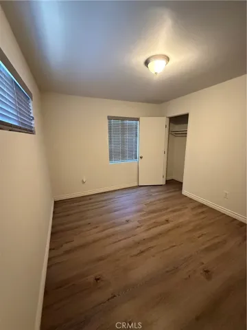 First bedroom with two windows and a closet.
