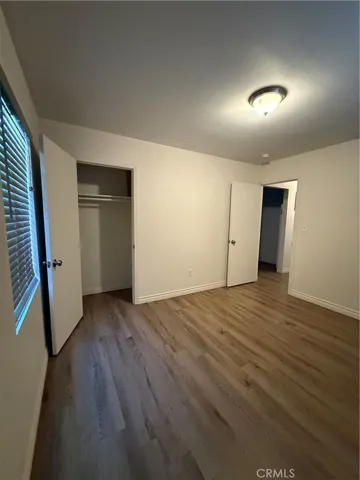 First bedroom with two windows and a closet.