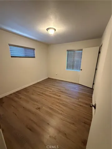 First bedroom with two windows and a closet.