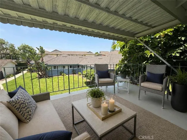 Virtually Staged Patio off the Living Room. Garages are Visible Mid-Ground Left (beige wall)