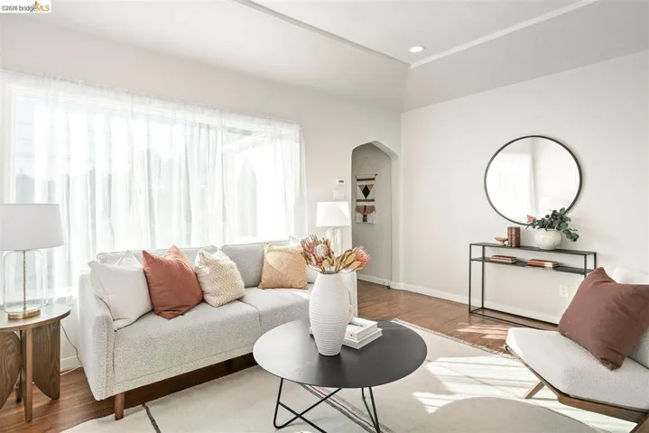 Bright living area featuring wood-finish flooring, recessed lighting, and an arched doorway