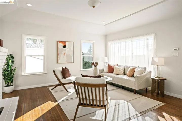 Spacious living area featuring wood-finish flooring, recessed lighting, and a tray ceiling