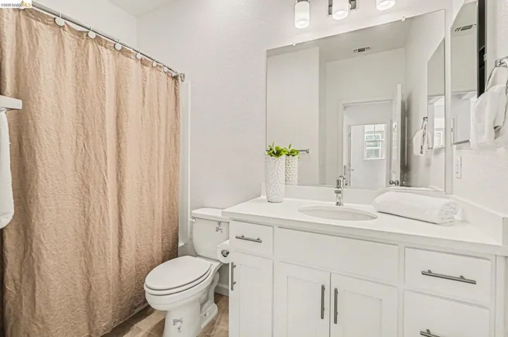 White vanity with integrated sink, chrome faucet, and contemporary vanity lighting