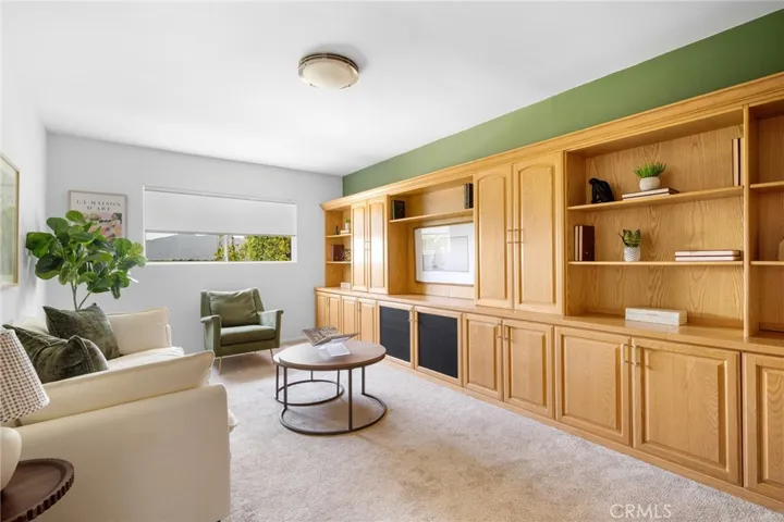 Warm, comfortable den with wall-to-wall built in storage and entertainment opportunities