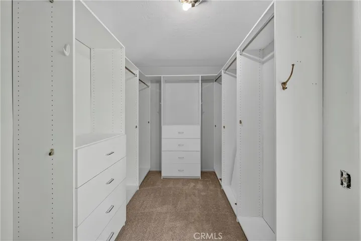 Primary bathroom includes a walk-in shower, dual sinks, dedicated vanity space, and a spacious walk-in closet, creating a comfortable private retreat