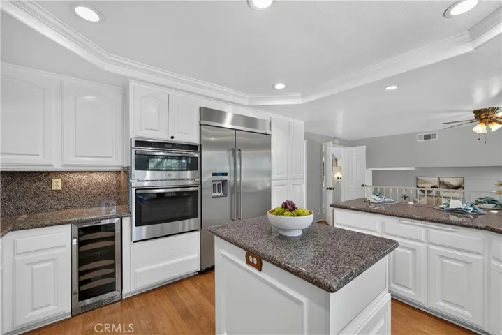Beautiful kitchen with granite countertops, breakfast bar, stainless steel appliances, and an oversized refrigerator