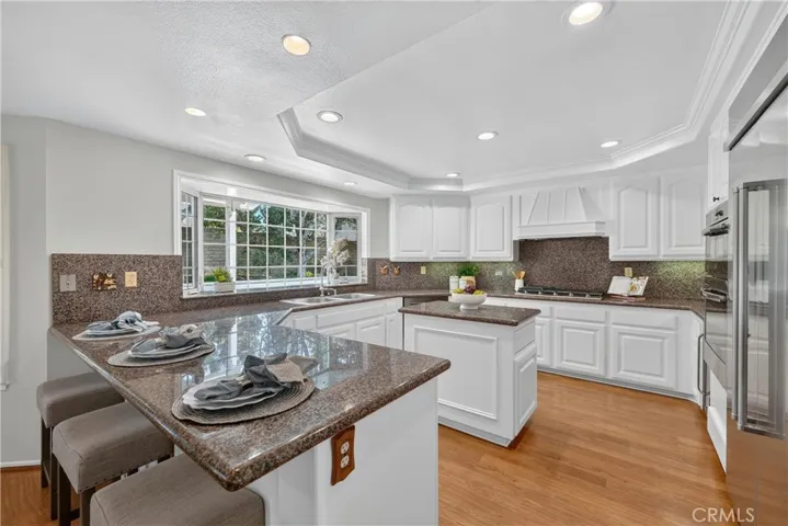 Beautiful kitchen with granite countertops, breakfast bar, stainless steel appliances, and an oversized refrigerator