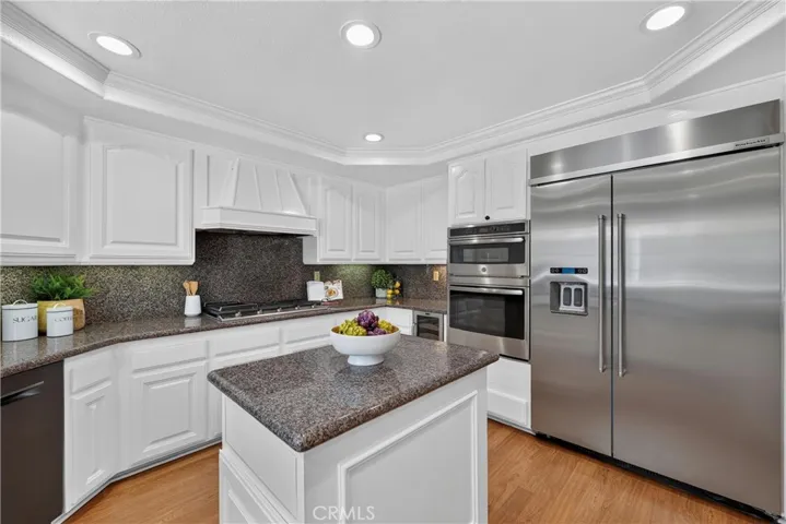 Beautiful kitchen with granite countertops, breakfast bar, stainless steel appliances, and an oversized refrigerator