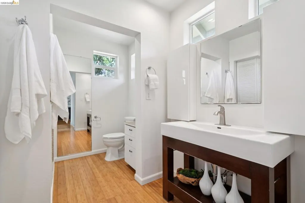 Modern bathroom featuring a rectangular vessel sink with a single-handle faucet, dark wood-finish vanity, and a wall-mounted mirror