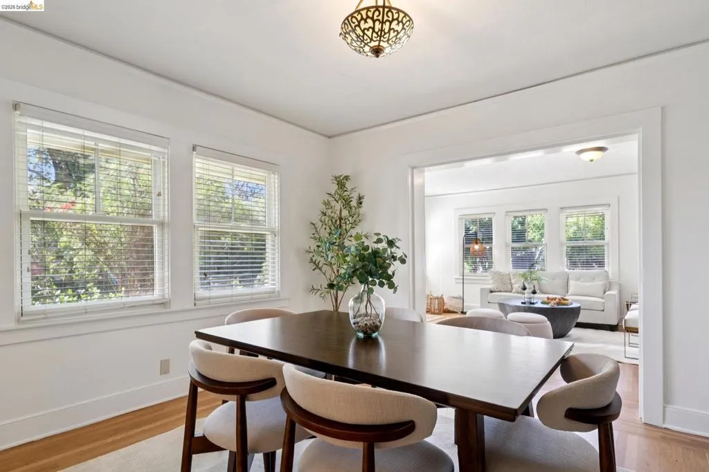 Dining area featuring wood-finish flooring, white baseboards, and double-hung windows