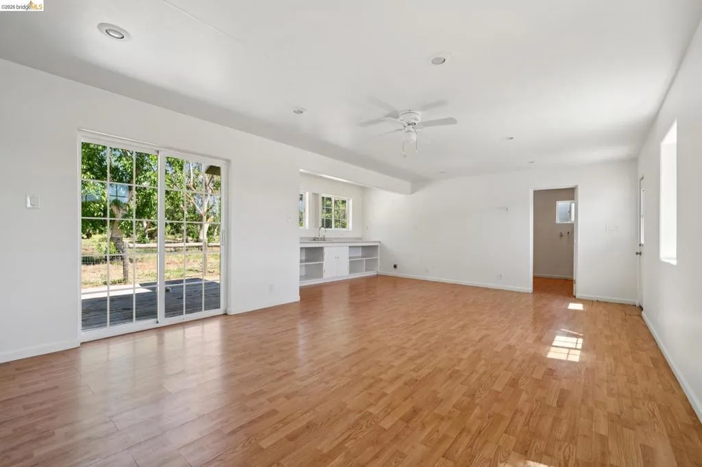 Open-concept interior featuring wood-finish flooring, white walls, and recessed lighting