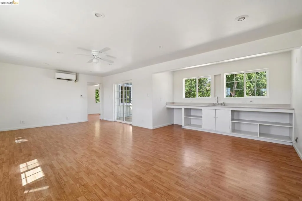 Spacious interior featuring wood-finish flooring, recessed lighting, and a ceiling fan