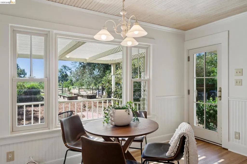 Dining area featuring a wood-finish ceiling, beadboard wainscoting, and an exterior door with multiple lites